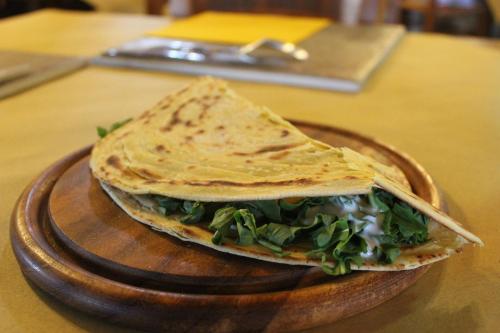 a tortilla sandwich on a wooden plate on a table at Agriturismo La Valle del Vento Urbino in Urbino