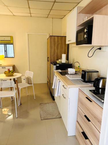 a kitchen with a table and a counter top at Studio Room with private kitchen and Bathroom in Ban Phlu Yai