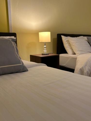 a bedroom with two beds and a lamp on a table at Studio Room with private kitchen and Bathroom in Ban Phlu Yai