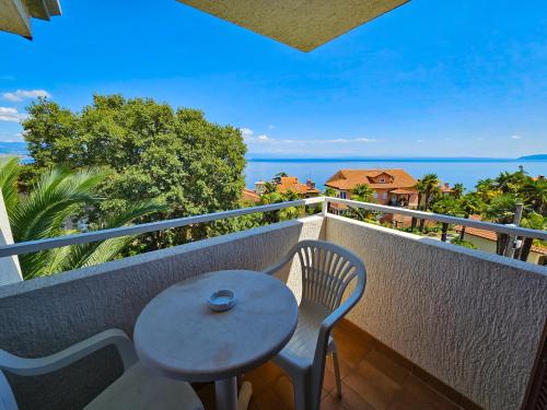 a table and chairs on a balcony with a view of the ocean at Rooms Tanja Lovran in Lovran
