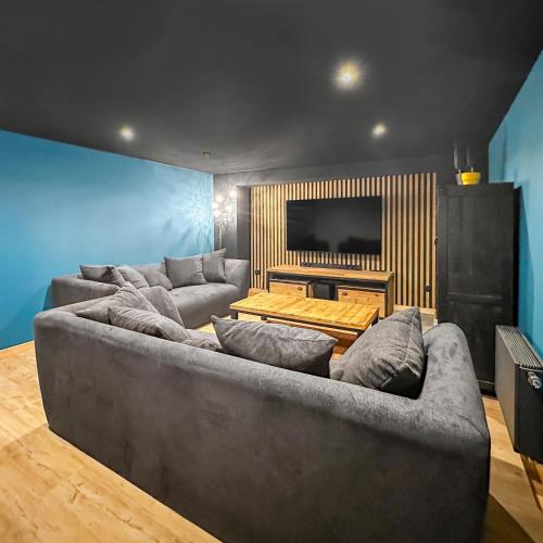 - un salon avec un grand canapé et une télévision dans l'établissement Retraite Paisible, Jardin, Plages et Centre Animé, à Dunkerque