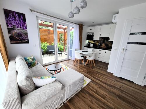 a living room with a white couch and a kitchen at Lawendowy Domek Boutique Resort, Zator, Przeciszów in Zator
