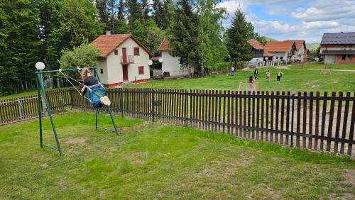 a young girl is playing on a swing at Ruža vetrova in Kušići