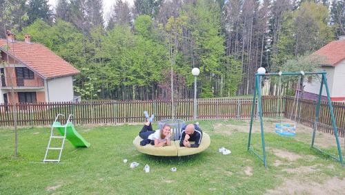 a man and a child laying on a playground at Ruža vetrova in Kušići