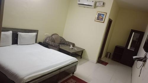 a bedroom with a bed and a chair and a table at Hotel The Diamond Ring 45B in Chandīgarh