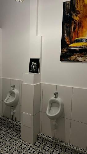 a bathroom with two urinals and a painting on the wall at Art of Sopot in Sopot