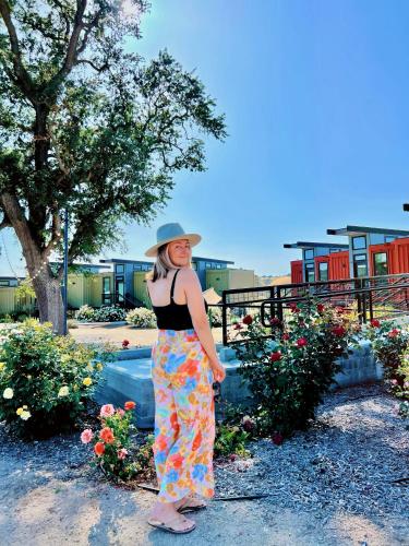 a woman wearing a hat standing next to flowers at Geneseo Inn in Paso Robles