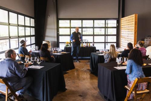 a man standing in a room with people sitting at tables at Geneseo Inn in Paso Robles