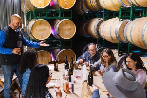 a group of people sitting around a table in a wine cellar at Geneseo Inn in Paso Robles