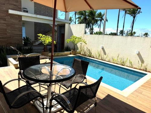 a patio with a table and chairs and a swimming pool at Apartamento Tulum in Barra Grande