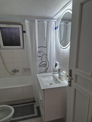 a bathroom with a shower curtain with a face drawn on it at Deco Apartments Aigina in Vaia