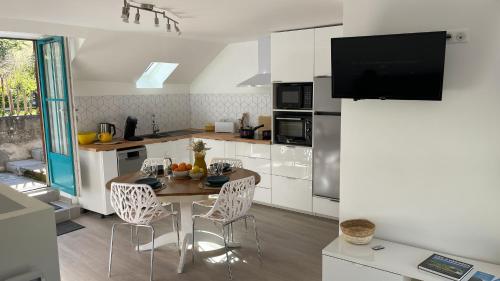 une cuisine avec une table et des chaises dans une pièce dans l'établissement Le Gypaète, à Gouaux