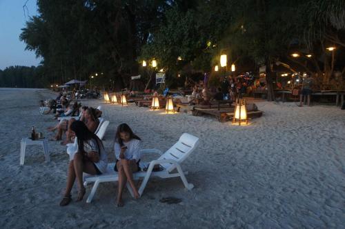 a group of people sitting in chairs on the beach at Lazy Hut in Ko Phayam