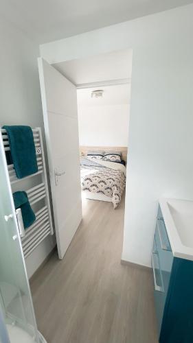 Cette chambre blanche comprend un lit et un miroir. dans l'établissement Le Gypaète, à Gouaux