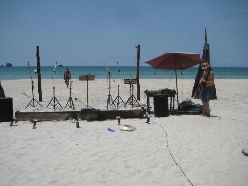 a woman standing on a beach with an umbrella at Lazy Hut in Ko Phayam