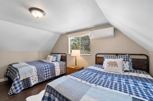 a attic bedroom with two beds and a window at Tollhouse Cottage Heart Of Shaver in Shaver Lake