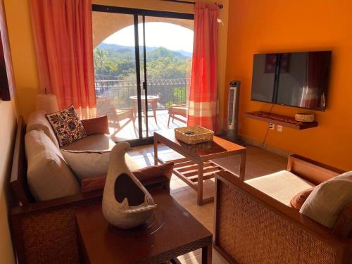een woonkamer met een bank en een tv bij Marina Park Plaza Sol in Santa Cruz Huatulco