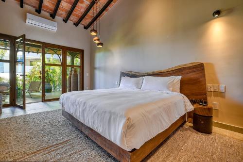 a bedroom with a large bed with a wooden headboard at Maxwell Residences at Indah in Puerto Vallarta