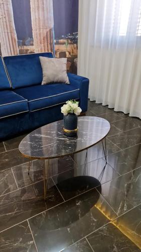 a living room with a blue couch and a glass table at Beatus Suites And Rooms B&B in Canicattì