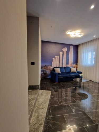 a living room with a blue couch and a painting at Beatus Suites And Rooms B&B in Canicattì