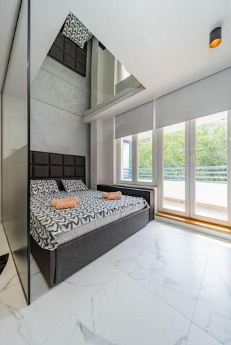 a bedroom with a bed and a large window at Zebrano Spa in Novi Beograd