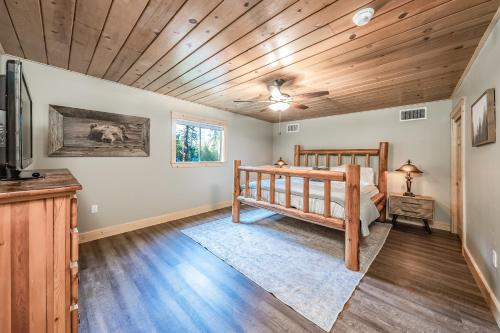 a bedroom with a bed and a wooden ceiling at The Sparrows Nest Cozy Charm Fire Pit Fun in Shaver Lake