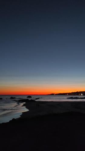 a view of a beach at sunset with the ocean at Hotel Amandi in O Grove