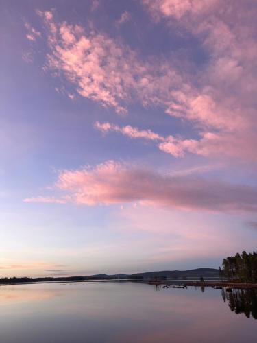 a cloudy sky over a large body of water at Laplandliv cabin on the lake with hottub in Björkliden