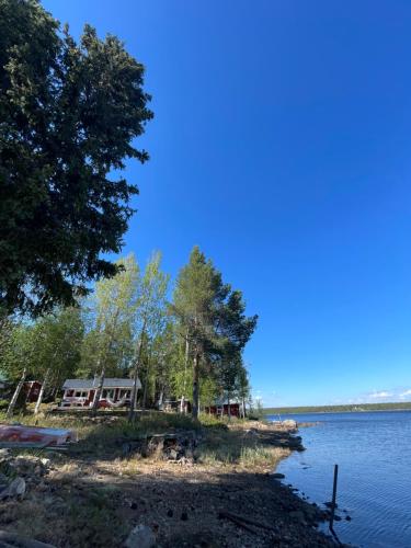 a house on the shore of a lake at Laplandliv cabin on the lake with hottub in Björkliden