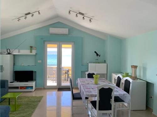 a dining room with a table and chairs in a room at Apartman LIVE in Posedarje