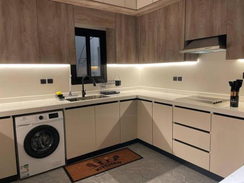 a kitchen with a sink and a washing machine at The N&N Appt in Al Madinah