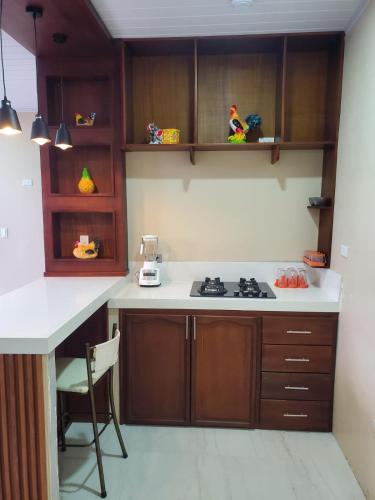 a kitchen with wooden cabinets and a stove top oven at Suite vista hermosa apartament in Macas