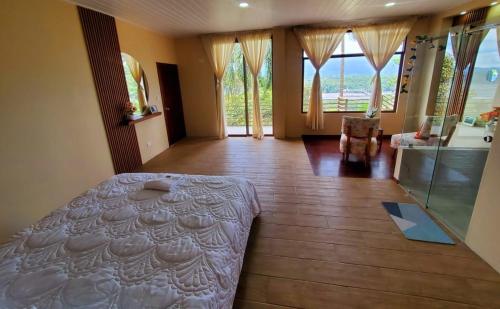 a bedroom with a bed in a room with windows at Suite vista hermosa apartament in Macas