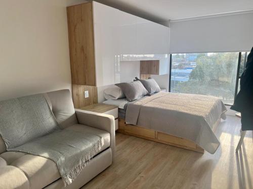 a bedroom with a bed and a couch at DF Acogedor Loft con Gym D02 in Bogotá