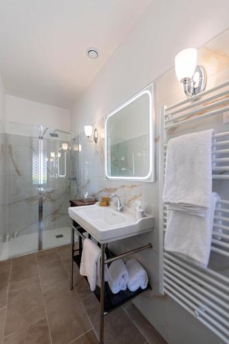 a white bathroom with a sink and a shower at Hôtel de la Poste à Avallon, Bourgogne in Avallon