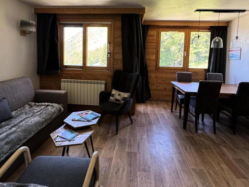 un salon avec un canapé, une table et des chaises dans l'établissement Résidence Le Centaure - 2 Pièces pour 4 Personnes 711, à Aime La Plagne