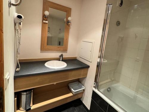une salle de bain avec un lavabo, un miroir et une baignoire dans l'établissement Résidence Le Centaure - 2 Pièces pour 4 Personnes 711, à Aime La Plagne