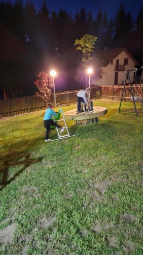 a group of people sitting on a park bench at night at Ruža vetrova in Kušići