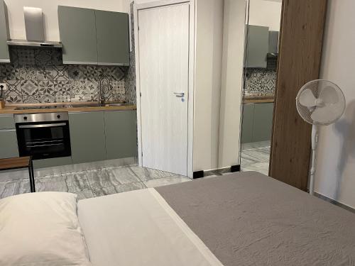 a room with a bed and a kitchen with a fan at Villa Gabri in Casa Berta