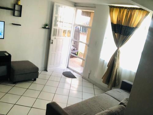 a living room with a couch and a window at La Casita Amarilla in Lázaro Cárdenas