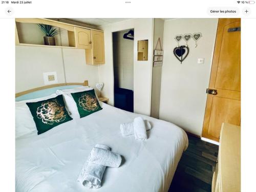 une chambre avec un lit blanc avec des serviettes dessus dans l'établissement Coin de paradis idéal nature, à Houlle