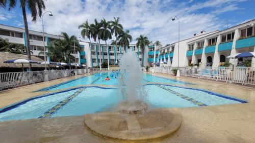 a fountain in a pool in front of a building at Hotel Bachue Girardot in Girardot