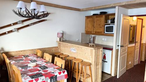 - une cuisine avec une table, des chaises et un comptoir dans l'établissement Résidence Le Mont Soleil A - 3 PIECES 6 pers balcon sud, sur pistes - PLAGNE SOLEIL MAE-9404, à Aime La Plagne