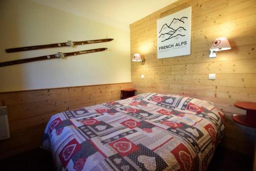 une chambre avec un lit avec une couette dessus dans l'établissement Résidence Le Mont Soleil A - 3 PIECES 6 pers balcon sud, sur pistes - PLAGNE SOLEIL MAE-9404, à Aime La Plagne