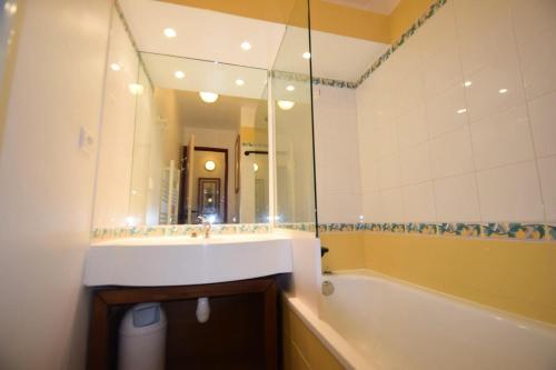 une salle de bain avec un lavabo, une baignoire et un miroir dans l'établissement Résidence Le Mont Soleil A - 3 PIECES 6 pers balcon sud, sur pistes - PLAGNE SOLEIL MAE-9404, à Aime La Plagne