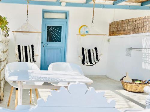 a white room with a blue door and white chairs at Little Troll House 1 in Chrissi Akti