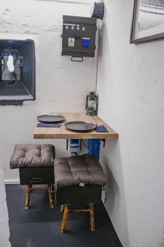 a table in a room with a table and a desk with stools at Vojenský bunker B in Bratislava