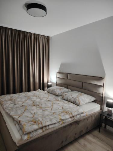a bedroom with a large bed with a large headboard at Downtown28 apartment in Poprad