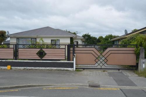 a fence in front of a house with at Shazza Homestay in Invercargill