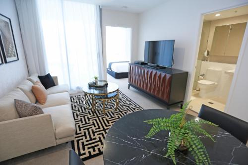 un salon avec un canapé, une table et une télévision dans l'établissement Alex Perry Hotel & Apartments, à Brisbane